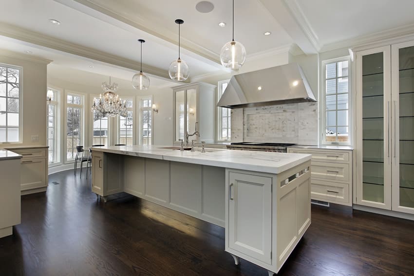 Stunning white kitchen with rectangular island and globe lighting