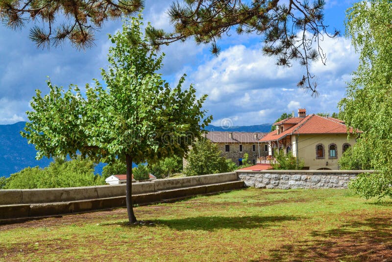 Beautiful landscape. Mountain village. A house with a tiled roof. Tree and blue sky. Montenegro.  stock photo