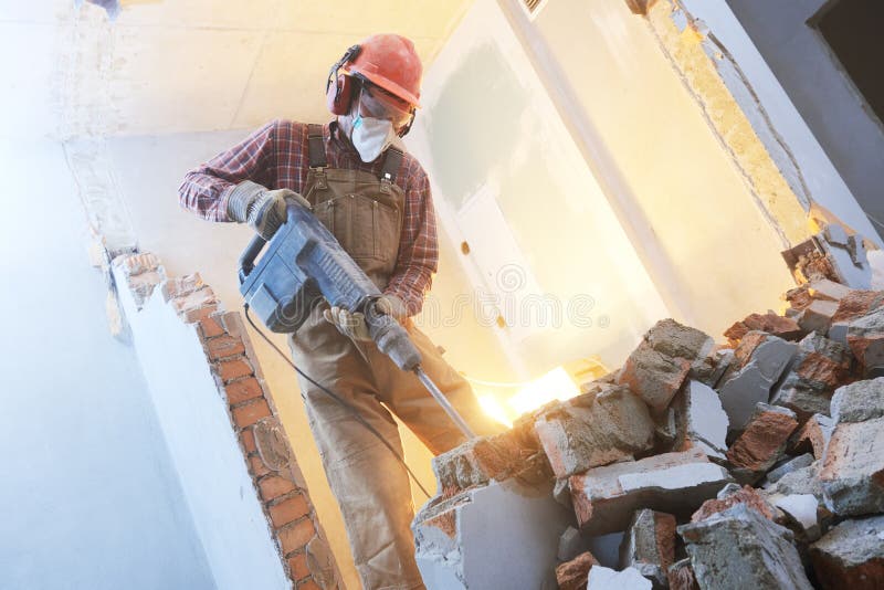 Breaking interior wall. worker with demolition hammer stock photos