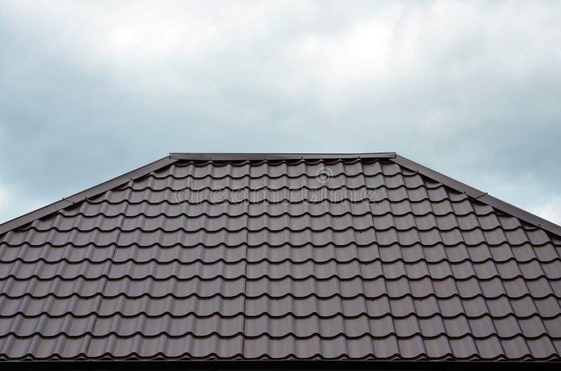 Brown roof tiles or shingles on house as background image. New overlapping brown classic style roofing material texture pattern o. N a actual house royalty free stock photography