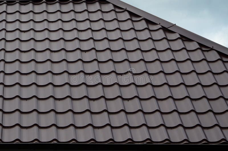 Brown roof tiles or shingles on house as background image. New overlapping brown classic style roofing material texture pattern o. N a actual house stock photography