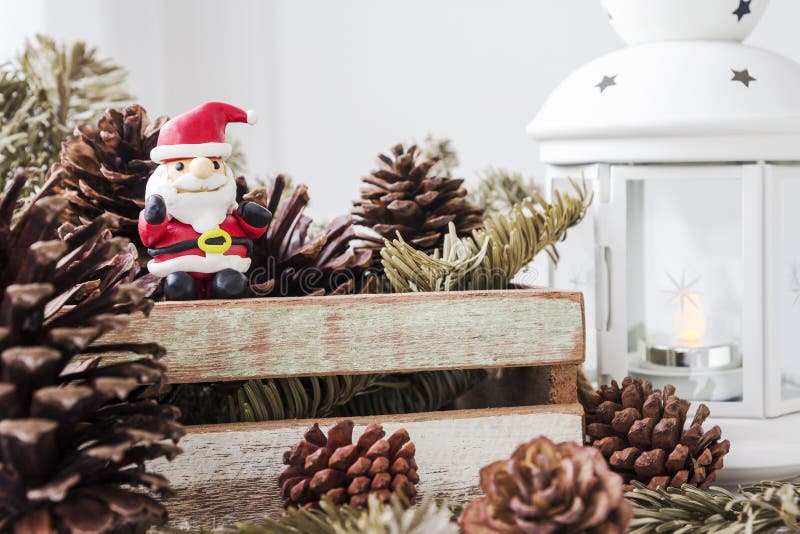 Christmas decoration of santa claus and pine cones on wooden cab. Inet royalty free stock images