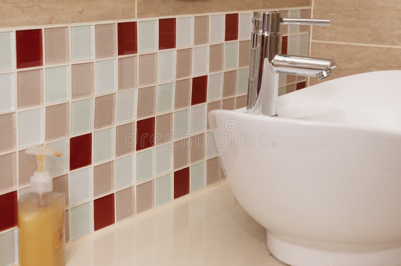 Classic bathroom sink with coloured mosaic splashback. Classic free standing bathroom basin and tap with coloured mosaic glass splashback royalty free stock image