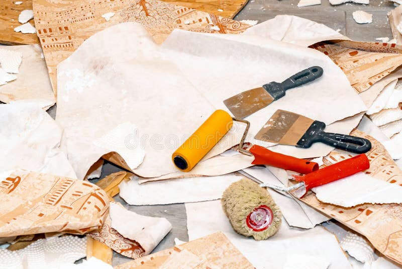 Construction debris in the repair of houses, apartments. Repair tools on the background of ragged, ragged WallpaperStill life from. Rolls of wall-paper and royalty free stock photo