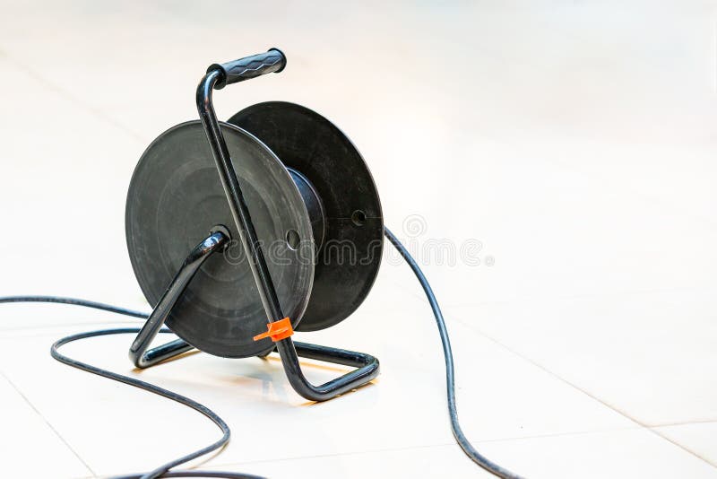 Power cord extension. The plug is inserted into the socket. Electrical cable extension reel. Rolled up sheathed electric cable for home or office to supply stock photography