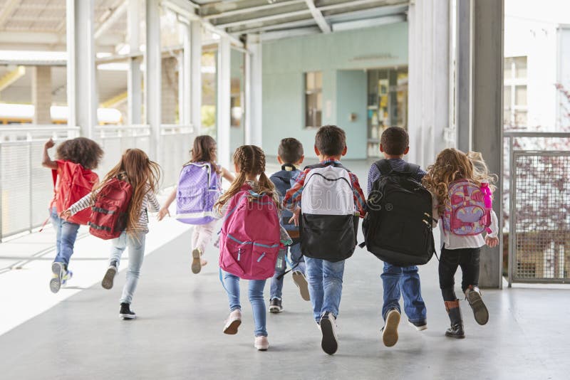 Elementary school kids run from camera in corridor, close up royalty free stock images