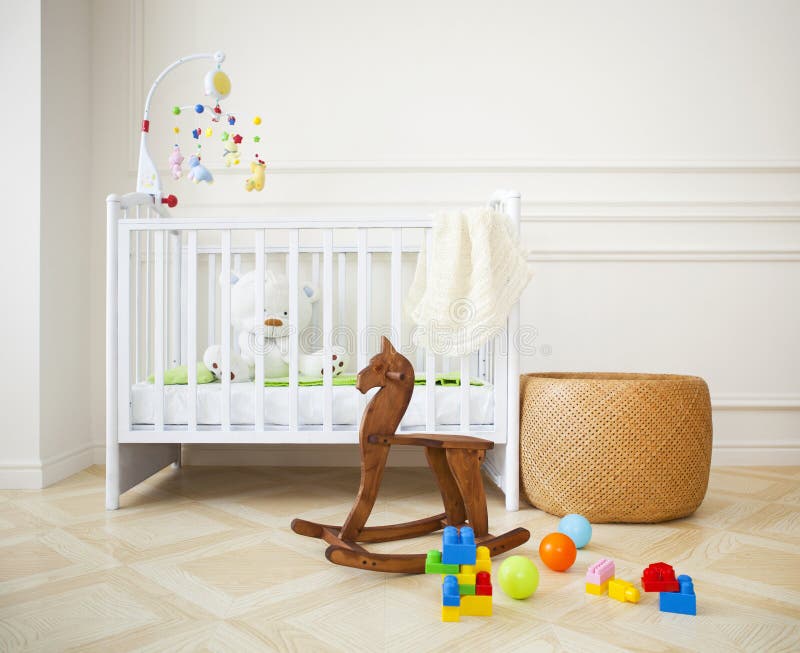 Empty cozy nursery room in light tones. Empty nursery room with basket, toys and wooden horse stock images