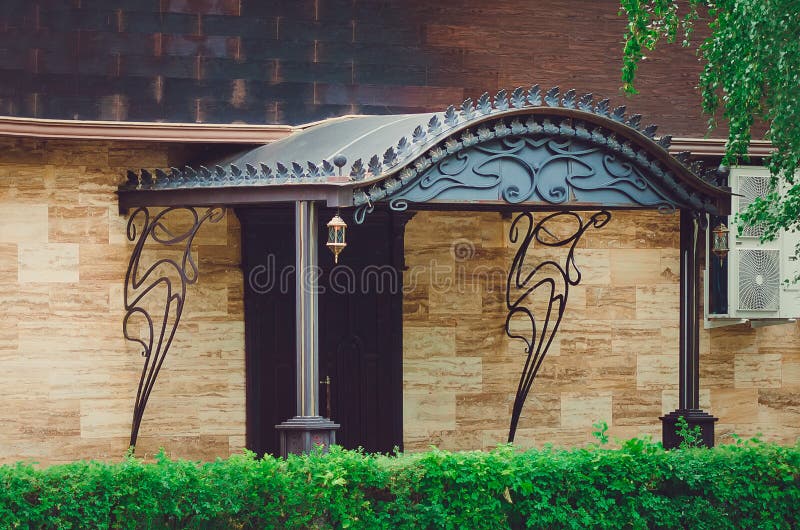 beautiful one-story house, a porch with an iron canopy. royalty free stock images