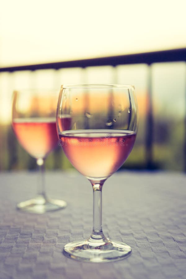 Enjoying a glass of rose wine on the veranda, summer holiday in Italy. Glass of rose wine outdoors on the balcony. Evening scenery, Italy enjoy vacation holiday royalty free stock image