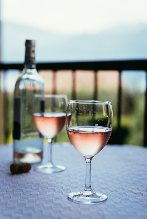 Enjoying a glass of rose wine on the veranda, summer holiday in Italy. Glass of rose wine outdoors on the balcony. Evening scenery, Italy enjoy vacation holiday royalty free stock images
