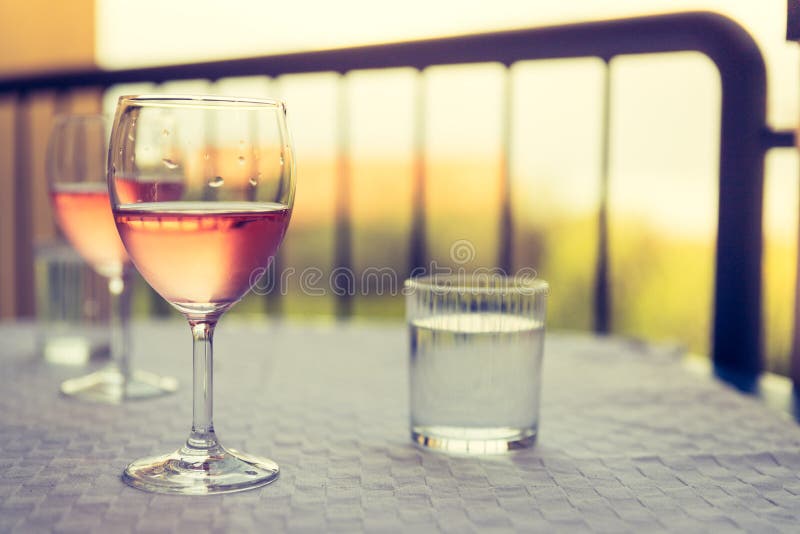 Enjoying a glass of rose wine on the veranda, summer holiday in Italy. Glass of rose wine outdoors on the balcony. Evening scenery, Italy enjoy vacation holiday stock images