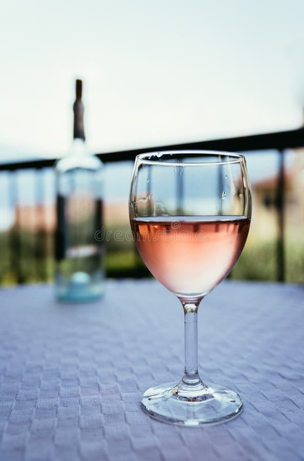 Enjoying a glass of rose wine on the veranda, summer holiday in Italy. Glass of rose wine outdoors on the balcony. Evening scenery, Italy enjoy vacation holiday royalty free stock photos
