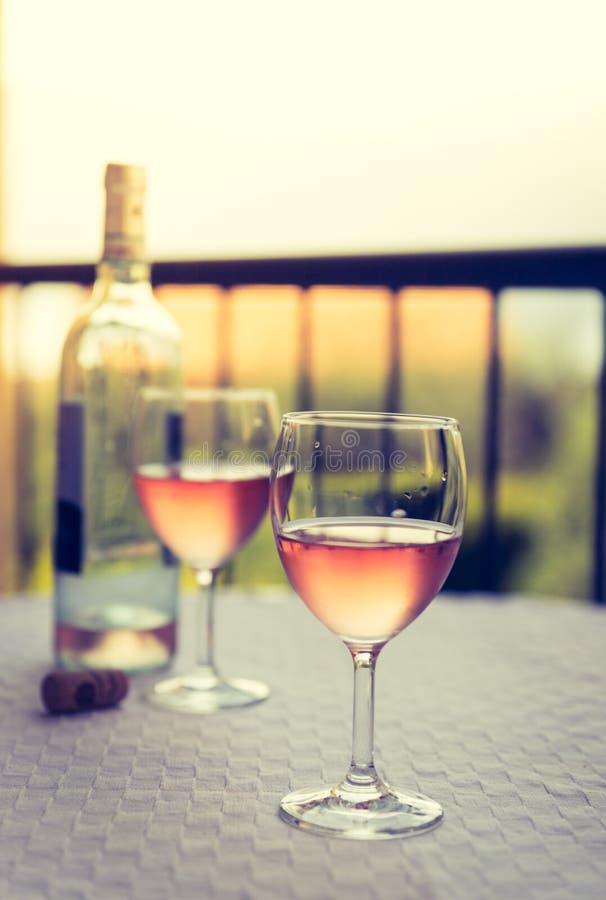 Enjoying a glass of rose wine on the veranda, summer holiday in Italy. Glass of rose wine outdoors on the balcony. Evening scenery, Italy enjoy vacation holiday stock photos