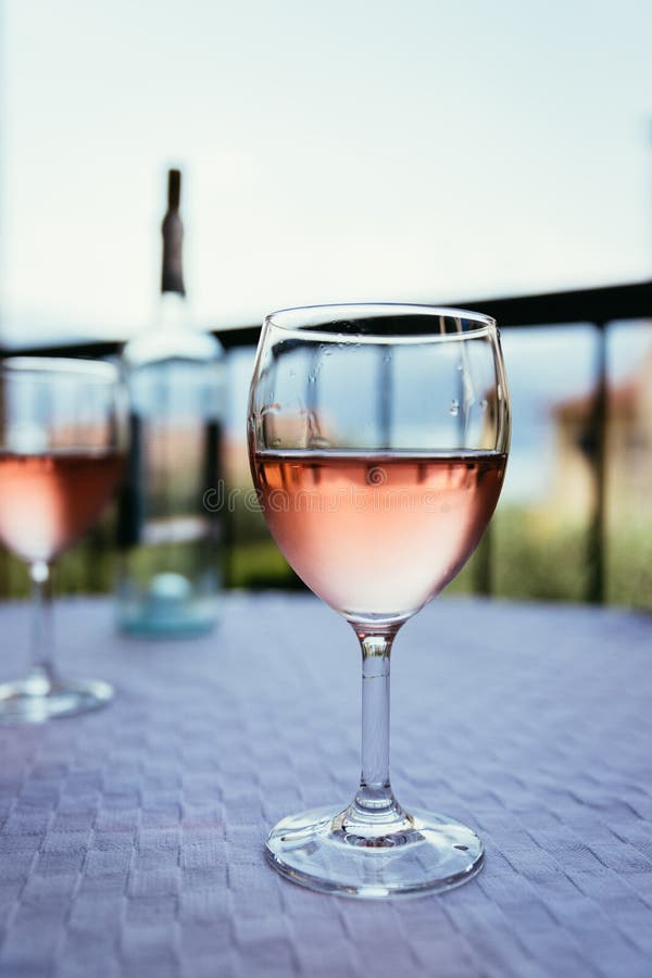Enjoying a glass of rose wine on the veranda, summer holiday in Italy. Glass of rose wine outdoors on the balcony. Evening scenery, Italy enjoy vacation holiday stock image