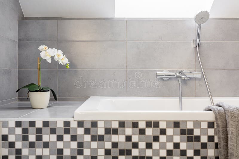 Grey bathroom with mosaic tiles. And bathtub royalty free stock images