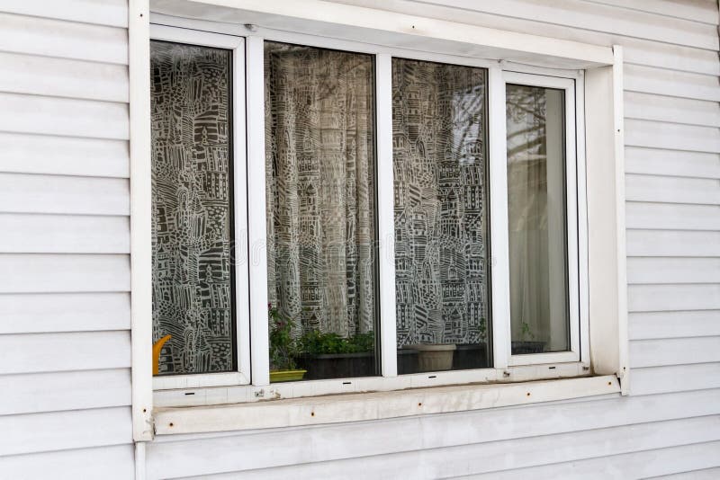 Large plastic window on the wall of siding. Large plastic window on the wall is sheathed with siding royalty free stock images