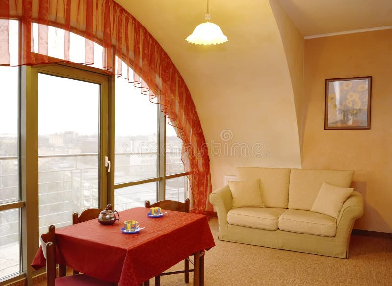 A living room interior fragment with a red lambrequin at a window and a picture on a wall.  stock photo