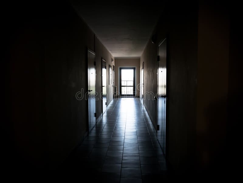 Long dark corridor with doors to the apartments. Gave the tunnel the light. an apartment building or Dorm black background royalty free stock photography