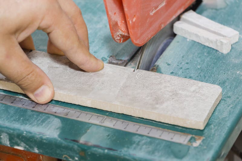 Master cuts the tiles on the saw. repair of apartments and houses. Master cuts the tiles on the saw. repair of apartments and houses stock image