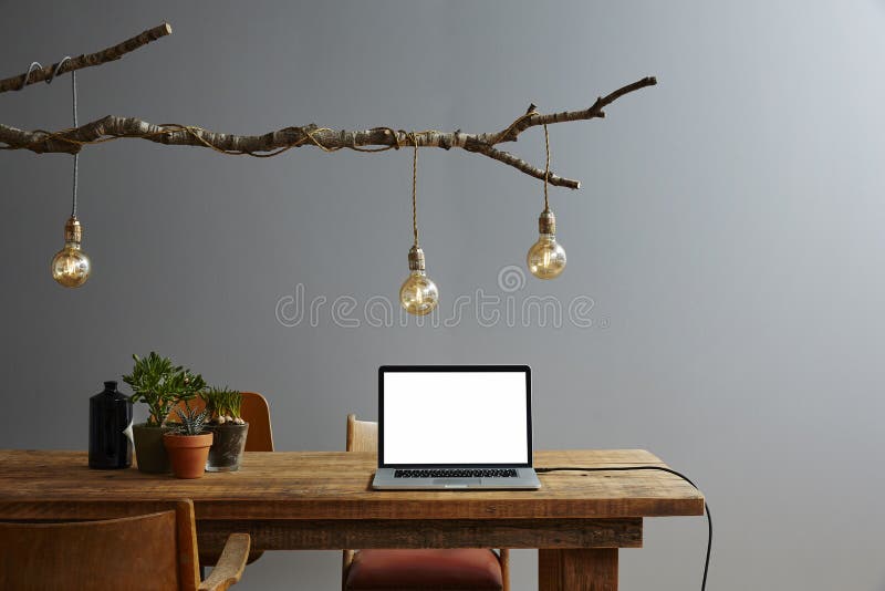 Modern workspace urban design laptop and design decoration. Birch branch lamp with vintage bulbs and modern high tech laptop royalty free stock photography