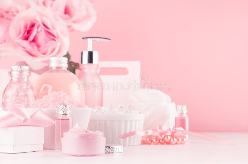 Modern youth bathroom or dressing table design in pastel pink color - fresh pink flowers, cosmetic products, bath accessories. stock photography