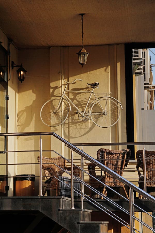 Street open veranda of cafe with a ladder, a bike on the wall and the old lantern in Moscow stock image