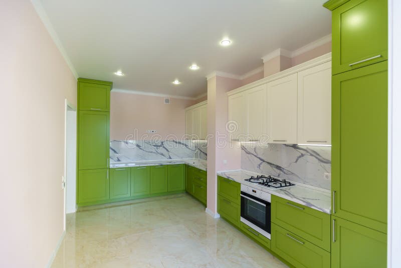 New kitchen set in green and white colors in the style of minimalism in a new building. The top under the marble. stock image