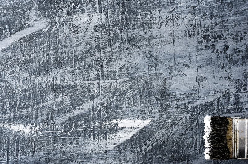 Part of the brush in black and white paint on a background of a concrete painted gray background from the top right to the bottom.  stock photos