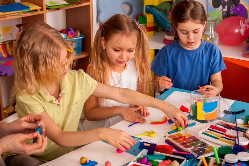 Plasticine modeling clay in children class. Teacher teaches in school. Plasticine modeling clay in children class. Teacher teaches kids together play dough and royalty free stock photography