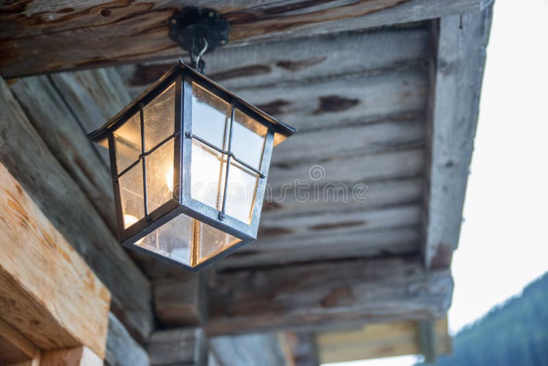 Lantern is hanging in on the veranda of an olden wooden hut royalty free stock image