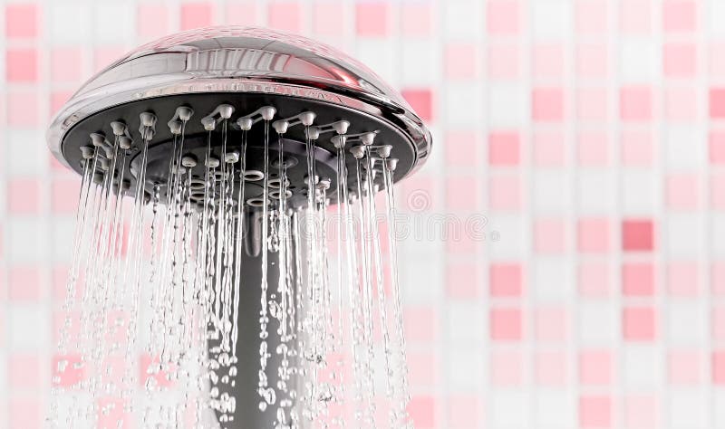 Shower head with flowing water stream in pink bathroom stock photos