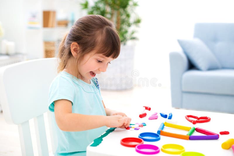 Smiling little beautiful girl sculpt new house of plasticine. Children creativity. Happy childhood. Housewarming dreams.  royalty free stock photography