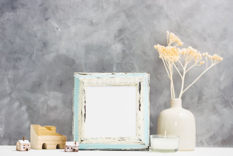 Square blue Photo frame mock up with dry beige plants in vase, wooden houses on shelf. Scandinavian style. Text space stock images