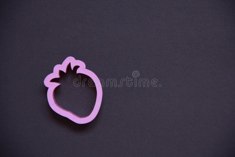 The strawberry in pink plastic on a black background. children`s form for plasticine stock photos