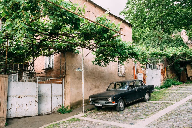 Tbilisi Georgia. Parked Black Volga GAZ Retro Rarity Car Near Private Residential House Under Vine Canopy On Cobbled stock photography