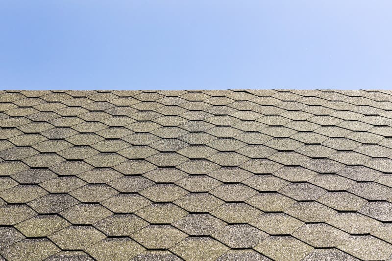 Textured roof of building with shingle covering against clear blue sky. Copyspace royalty free stock image