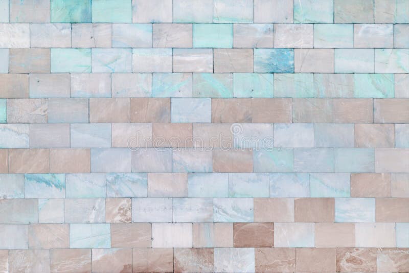 The wall is made of marble turquoise and pale brown tiles. Beautiful stone texture. Empty background. The wall is made of marble turquoise and pale brown tiles royalty free stock photo