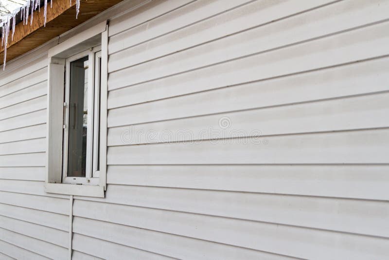 Window in the wall. With a window wall is sheathed with siding stock photography