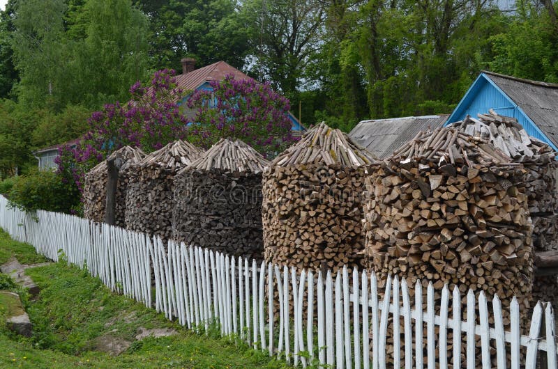 Large heaps of firewood are standing near the houses. royalty free stock images