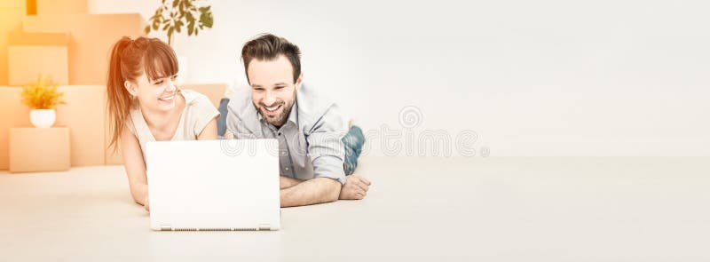 Young people move into a new apartment. A young couple sitting in a new apartment and uses a laptop. Discuss home repair projects while moving royalty free stock images