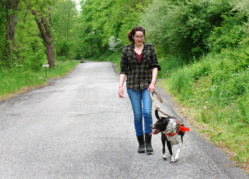 Young Woman Walking her dog for exercise royalty free stock image