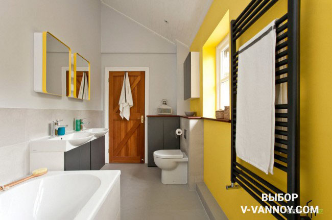 Стена и рамки для зеркал в желтом цвете, а также дверь деревянной фактуры оживляют спокойные оттенки в помещении.